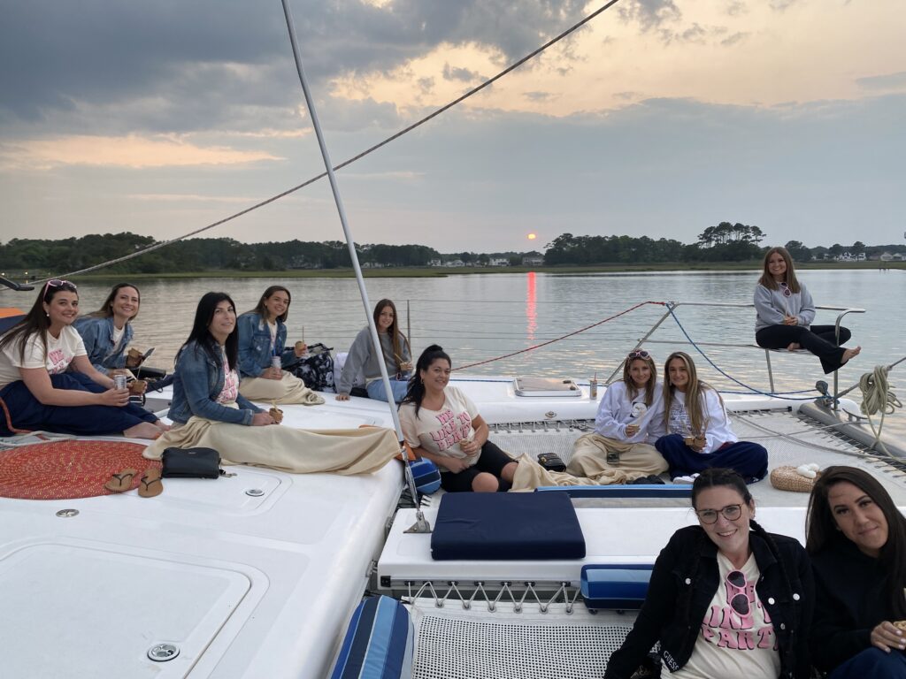 Families and guests relaxing on Alyosha catamaran trampoline during calm bay sailing tour
