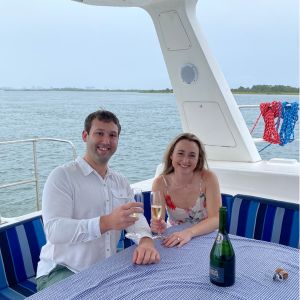 A couple on romantic date celebrating on back of sailboat their recent proposal