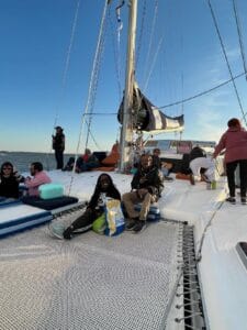 Guests spread out on Alyosha catamaran deck during 3-hour Ocean Sailing Advanced trip on Atlantic Ocean