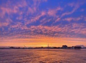 Sunset cruise Ocean City Maryland showing dramatic purple and orange sky over Sinepuxent Bay