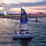 Sail Alyosha catamaran at sunset with Ocean City Boardwalk skyline visible in background