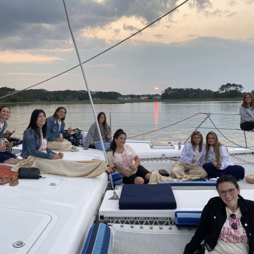 Families and guests relaxing on Alyosha catamaran trampoline during calm bay sailing tour