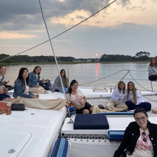 Families and guests relaxing on Alyosha catamaran trampoline during calm bay sailing tour