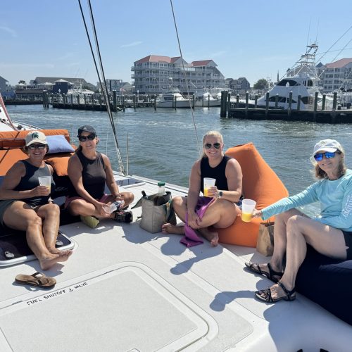 Family relaxing on Alyosha catamaran deck during morning bay sailing tour