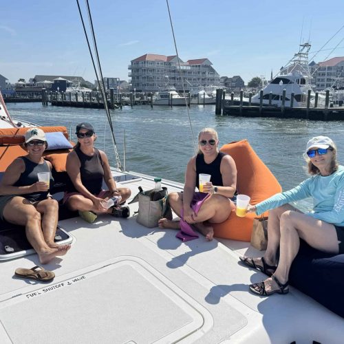 Family relaxing on Alyosha catamaran deck during morning bay sailing tour