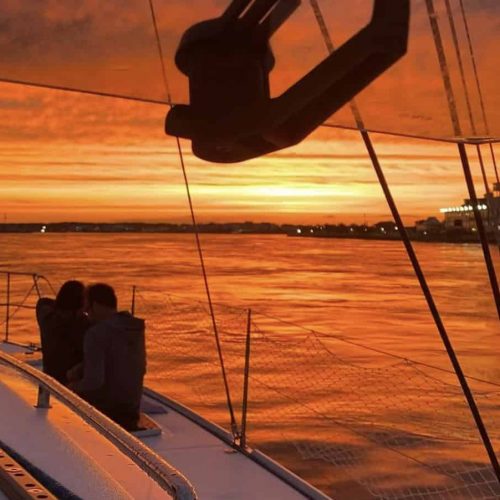 Romantic sunset cruise Ocean City aboard Alyosha sailing catamaran with couple watching sunset